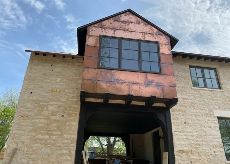 Copper metal panel facade on a stone building for Skylight Installation in Mountain Home